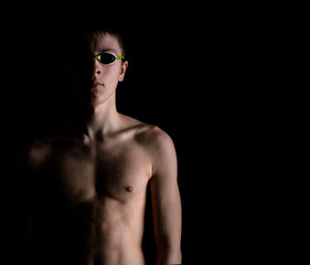 Fototapeta na wymiar Young swimmer in glasses- picture in low key.