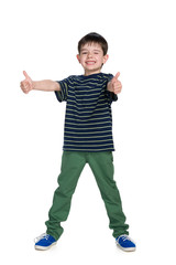 Young boy in a green trousers holds his thumbs up