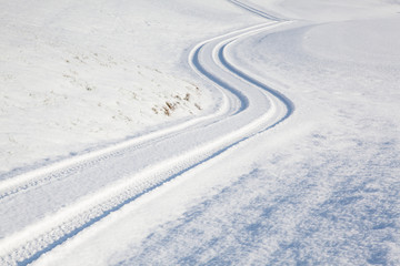 Car tire track on winter road