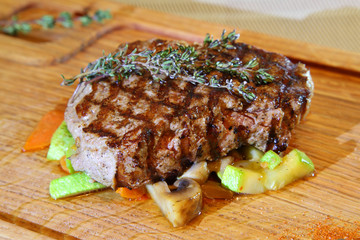 Beef steak medium rare on vegetable cushion. Delicious steak. Beef steak on wooden plate plate. - Stock Image