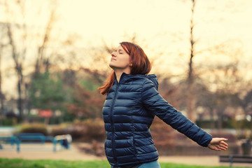 Young woman breathing fresh air before a run.Freedom happy young woman feeling alive and free in a...