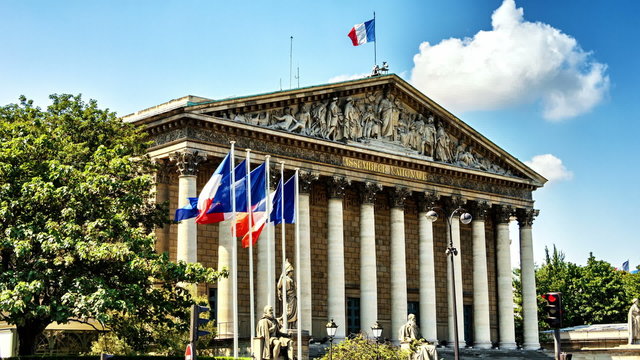 French and EU flags waving in front of building of National Assembly. Paris, France