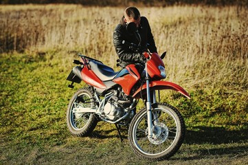 Fototapeta na wymiar Motorcycle rider stay at sunset with him enduro bike