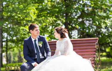 Wedding couple sitting on a bench 