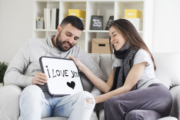 Young couple showing love message written on white board. I love you message. Valentines couple,shallow depth of filed