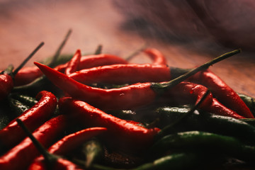 red and green chili peppers close up on wooden background