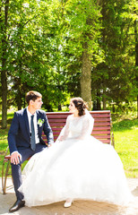 Portrait of a happy bride sitting on a bench with the groom