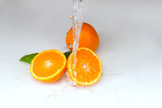 pomarańcze polane wodą na białym tle