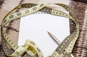 Diet concept. Empty notepad, tape measure and pen