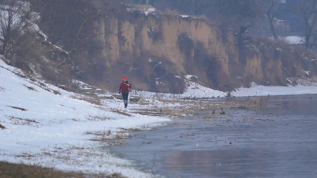 Девушка бежит по берегу реки