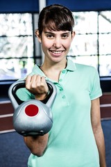 Obraz premium Portrait of woman holding kettlebell
