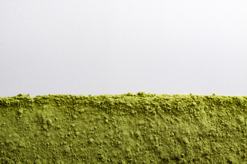 Frame of green powder superfoods on white.
