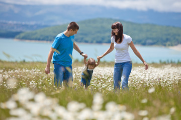 Happy family in a camomile field 