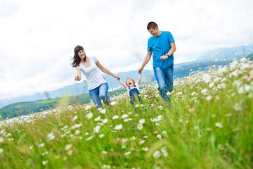 Happy family in a camomile field 