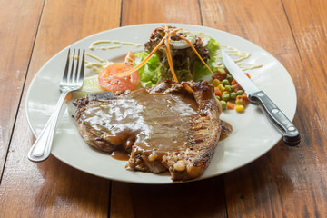 T bone steak in white plate on table