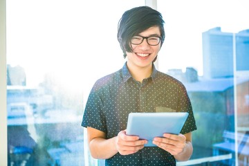 Smiling hipster businessman using tablet
