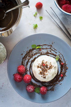 Dessert plating: vanilla panna cotta with chocolate sauce and fresh raspberries