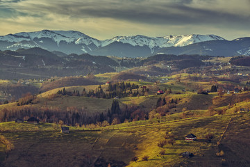 Rural scenery with early morning sunlight over the hills and valleys in Bran-Rucar pass, Sirnea village, Brasov county, Romania.