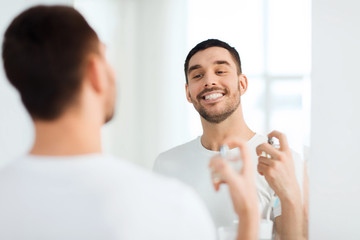 man with perfume looking to mirror at bathroom