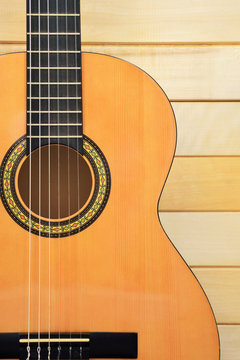 Acoustic guitar closeup front view on wooden background