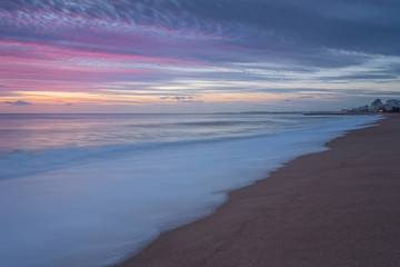 Pink sunset on the beach in Quarteira. Portugal for tourists.