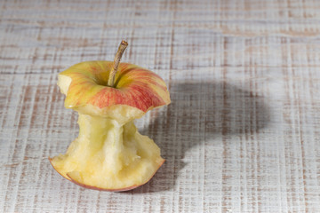 Apple core on a wooden table. With Shadow.