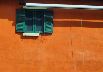 green window and orange color wall with sunshine