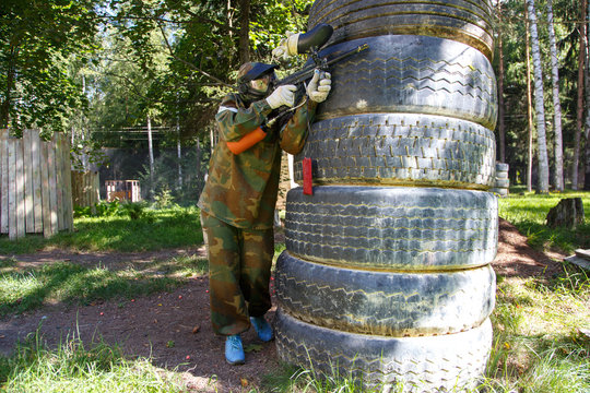 Paintball player behind giant truck tire fortification