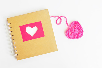 Book of love with pink crochet heart on white background