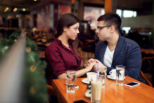 Lovely young couple looking at each other at cafe in trade center. Copy space for your text. Shallow depth of field. Very useful photo for processing with one click on edit image.