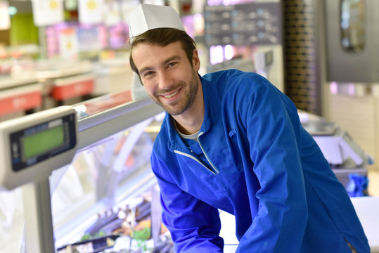 Portrait of smiling fishmonger with blue uniform