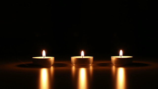 three small candles with wind