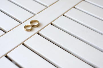 Wedding rings on white wooden background