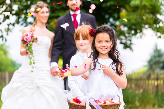 Hochzeit Braut und Bräutigam mit Blumenkinder im weißen Kleid