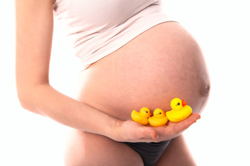 funny pregnant woman  with children's toys (yellow ducklings ),