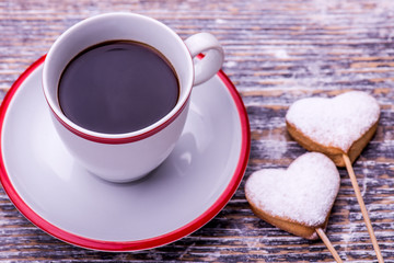 Coffee cup and biscuits, cookies in the shape of heart on wooden background. St.Valentines Day.