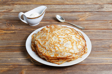 Pancakes on the dish and sour cream