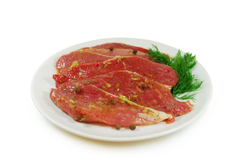 Raw meat. Pork escalope slices with sause  in a Dish Isolated Against White Background