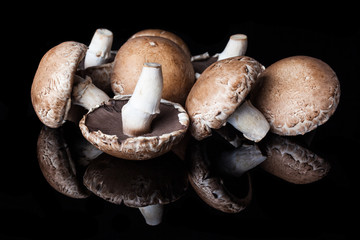 View from side on few big brown champignon mushrooms 