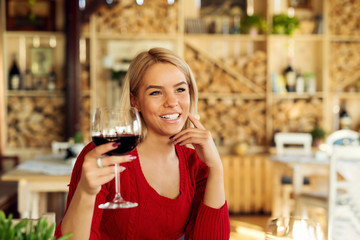 Attractive beautiful young woman tasting wine and flirting at restaurant.