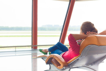 woman waiting for her flight at the airport on lounge chair