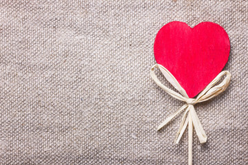 Wooden heart shape on linen fabric.