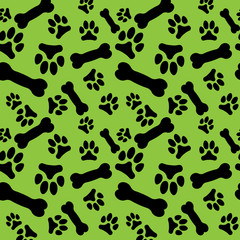 Fototapeta na wymiar Seamless pattern with black dog paw prints and bones on a green background
