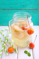 a jug of apple compote on a bright wooden background
