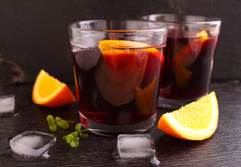 cold cocktail with orange and mint on a black background