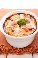 chicken baked with spices in a white plate on a dark background