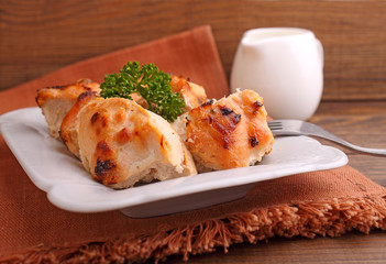 chicken baked with spices in a white plate on a dark background