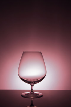 Transparent glass, magenta background, close up.