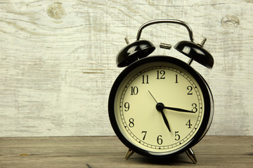 Old alarm clock on a wooden background