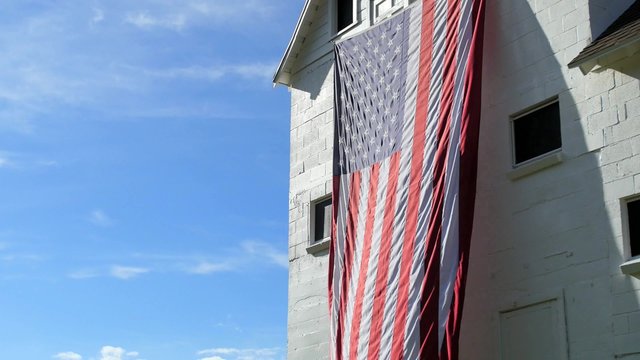 An American flag waves on the side of a picturesque white barn in the mountains outside of Park City, Utah.